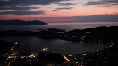 Güneş dramatik ve renkli bir şekilde batarken, Yunanistan 'daki Ios limanının panoramik manzarası