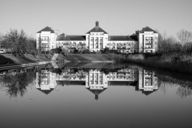 Bir yerleşim yeri manzarası ve gölün siyah beyaz yansıması. 