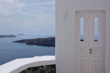Güzel, beyaz bir kapı ve arka planda Santorini Yunanistan 'ın Fira köyü. 
