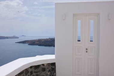 Tipik bir beyaz kapı ve Ege Denizi manzarası ve Santorini Yunanistan volkanı.