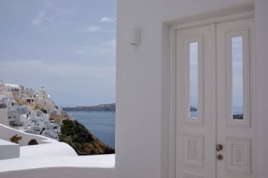 Tipik bir beyaz kapı ve Ege Denizi manzarası ve Santorini Yunanistan volkanı.