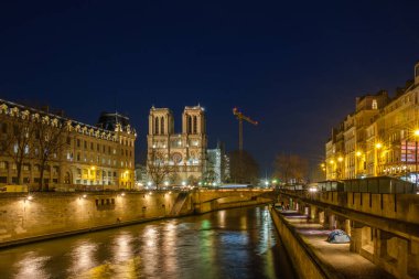 Paris, Fransa - 11 Şubat 2022 Notre Dame 'ın aydınlatılmış ünlü katedrali ve Paris' teki Seine nehri