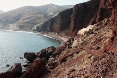 Santorini 'de rüzgarlı bir günde meşhur kızıl kumsalın panoramik manzarası 