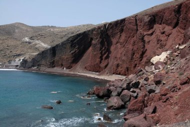 Santorini 'de rüzgarlı bir günde meşhur kızıl kumsalın panoramik manzarası 