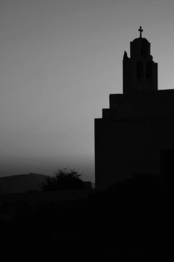 Bir Yunan Ortodoks Kilisesi ve Santorini 'de siyah beyaz gün batımı