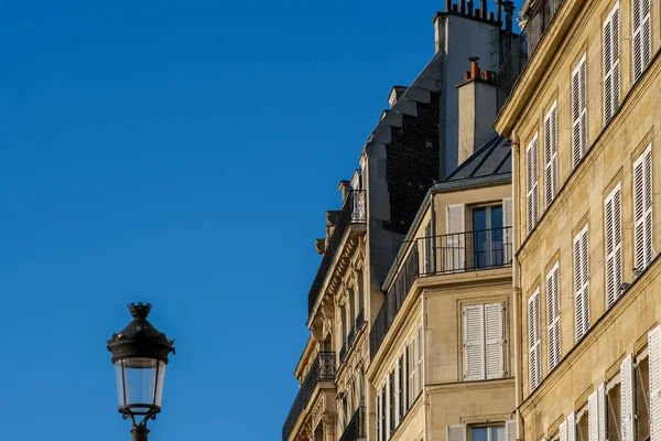 在巴黎的一个美丽的日子里 一个灯笼和一个有阳台和烟囱的典型的巴黎住宅建筑的景象 — 图库照片
