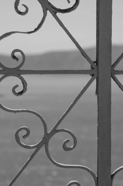 Geleneksel metalik bir kapının parçası ve Santorini 'deki Ege Denizi' nin siyah beyaz görüntüsü.