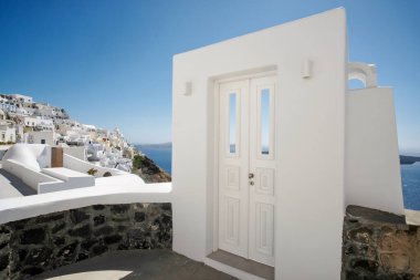 Tipik tasarım beyaz dekorasyon kapısı Santorini 'deki Fira ve Ege Denizi' nin nefes kesici manzaralı bir ara sokağın yanında.