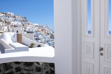 Tipik tasarım beyaz dekorasyon kapısı Santorini 'deki Fira ve Ege Denizi' nin nefes kesici manzaralı bir ara sokağın yanında.
