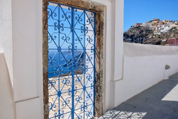 An external decorated door on the roof of a villa and  view of the aegean sea in Fira Santorini