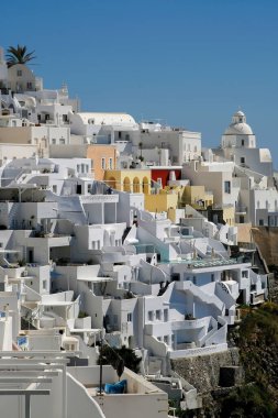 Fira Santorini 'nin panoramik manzarası. Otelleri, restoranları ve villaları siyah beyaz.