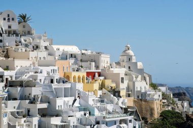 Fira Santorini 'nin panoramik manzarası. Otelleri, restoranları ve villaları siyah beyaz.