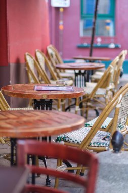 Montmartre Paris 'in pitoresk bölgesinde bir restoranda geleneksel boş sandalyeler ve masalar.