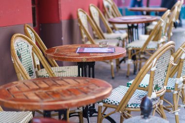 Montmartre Paris 'in pitoresk bölgesinde bir restoranda geleneksel boş sandalyeler ve masalar.