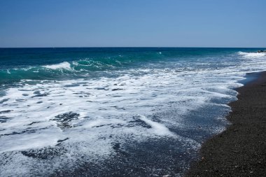 Dalgalar ve mavi gökyüzü ile güzel deniz kıyısı