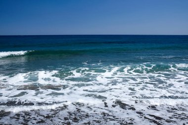 Dalgalar ve mavi gökyüzü ile güzel deniz kıyısı