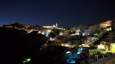 Panoramic view of the illuminated village of Fira by night in Santorini Greece