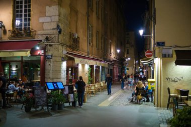 Lyon, Fransa - 10 Mayıs 2022: Açık hava restoranlarında yemek yiyen turistler ve geceleri eski Lyon kentinden geçen diğerleri