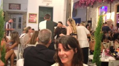 Ios, Yunanistan - 13 Haziran 2021: Yunanistan 'daki Ios adasının ana meydanında eğlenen turistler