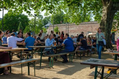 Bonn, Almanya - 18 Mayıs 2022: İnsanlar Ren nehrinin yanındaki Alter Zoll adlı açık hava terasında soğuk bira ve diğer içeceklerin keyfini çıkarıyorlar.