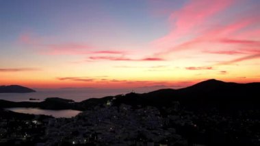 Güneş dramatik ve renkli bir şekilde batarken, Yunanistan 'daki Ios limanının panoramik manzarası