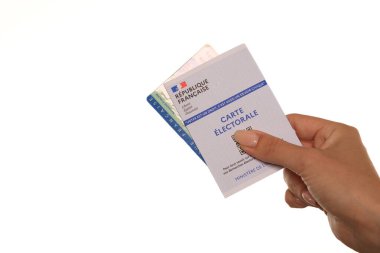 Paris, Fransa - 26 Mayıs 2022: Fransız ulusal kimlik kartı tutan bir kadın ve beyaz arka planda bir Fransız seçim kartı