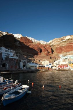 Ammoudi 'nin panoramik manzarası, volkanik manzarayla çevrili balık tavernaları olan küçük liman.