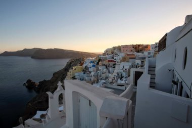 Oia Santorini 'nin beyaz boyalı ve resimli küçük evleri ve otelleri.