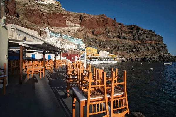 Tables of a restaurant in front of the aegean Sea in the famous Ammoudi Fish Tavern area of Oia Santorini