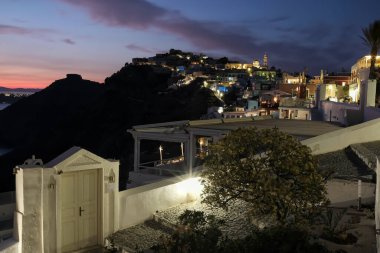 Santorini, Yunanistan - 12 Mayıs 2021: Fira Santorini 'de geleneksel bir otelin girişi ve mor gün batımının görüntüsü