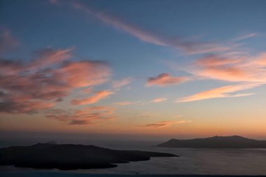 Kalderanın panoramik manzarası, Santorini volkanı ve güzel renkli bir gökyüzü.