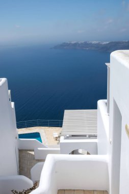 Güneşli yatakları, yüzme havuzu ve Santorini Yunanistan 'daki Ege Denizi üzerinde nefes kesici manzarası olan güzel bir teras.