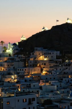 Panoramic view of the picturesque illuminated island of Ios in Greece while the sun is setting