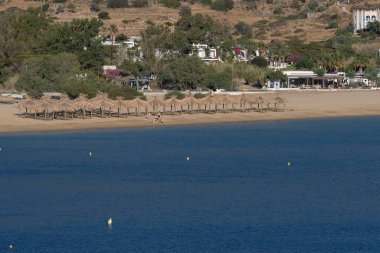 Ios, Greece - June 9, 2021 : View of the famous sandy beach Mylopotas  in Ios Greece with sunbeds and sun umbrellas