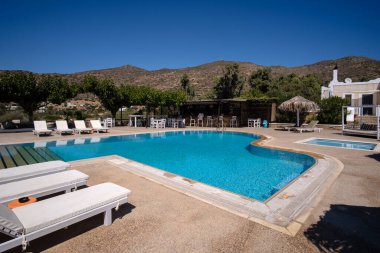 Ios, Yunanistan - 13 Eylül 2022: Güneş yatakları, güneş şemsiyeleri ve Yunanistan 'da bir havuz manzarası