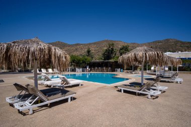 Ios, Yunanistan - 13 Eylül 2022: Güneş yatakları, güneş şemsiyeleri ve Yunanistan 'da bir havuz manzarası