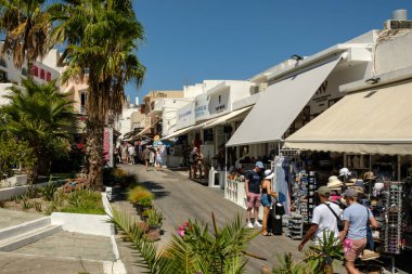 Fira, Yunanistan - 5 Eylül 2022: Fira Santorini Yunanistan 'ın merkezinde hediyelik eşya dükkanlarının yanında yürüyen turistleri görmek