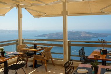 Fira, Santorini - 4 Eylül 2022: Fira ve Volkan 'ın resimli köyüne bakan çarpıcı bir terası olan güzel bir restoran manzarası