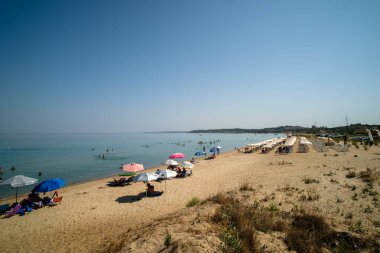 Nea Potidea, Yunanistan - 29 Ağustos 2022: Yunanistan 'ın Chalkidiki kentindeki Potidea' nın güzel ve kalabalık sahil barının panoramik manzarası