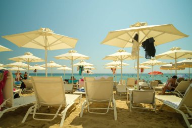 Nea Plagia, Yunanistan - 28 Ağustos 2022: Yunanistan 'da Chalkidiki' de bir sahil barında güneşli yatak ve şemsiye manzarası