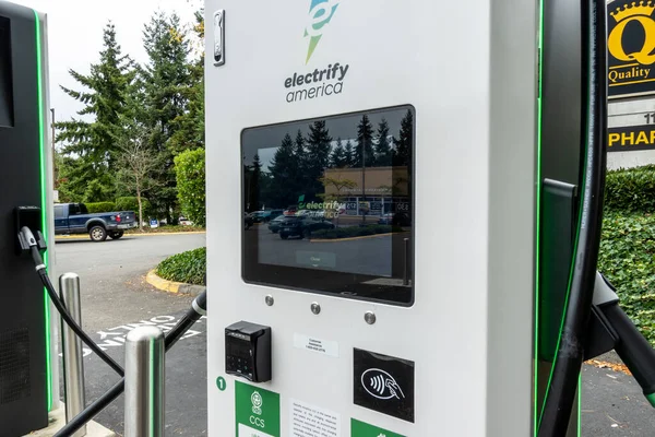 Kirkland, WA USA - Eylül 2021: QFC marketinin otoparkındaki bir elektrikli araba şarj istasyonunun sokak manzarası.