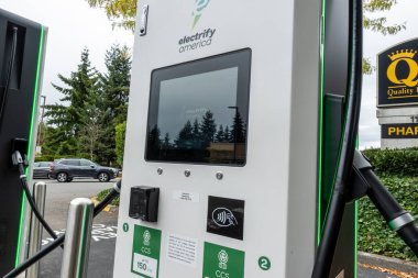 Kirkland, WA USA - Eylül 2021: QFC marketinin otoparkındaki bir elektrikli araba şarj istasyonunun sokak manzarası.