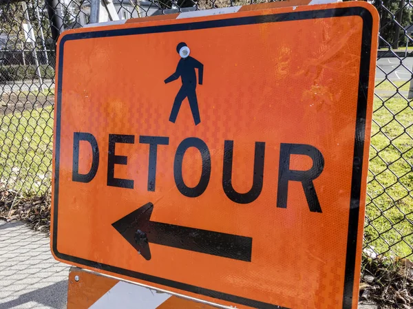 工事現場近くの歩道上のオレンジ色の迂回路標識の角度表示 — ストック写真