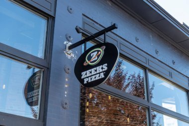 Tacoma, WA USA - Ağustos 2021: Güneşli bir günde şehir merkezinde bir Zeek 's Pizza tabelasının alçak açılı görüntüsü.
