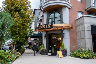 Woodinville, WA USA - Eylül 2021: Woodinville şehir merkezinde Brix Wine Cafe 'nin önünden geçen bir kadının sokak manzarası.