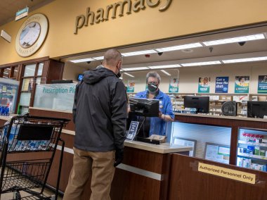 Kirkland, WA USA - Ekim 2021: Safeway 'deki bir marketten reçeteli ilaç alan orta yaşlı bir adamın görüntüsü