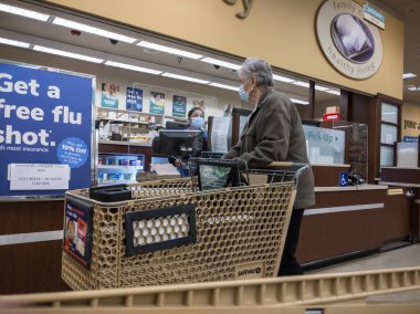 Kirkland, WA USA - Ekim 2021: Safeway 'deki bir marketten reçeteli ilaç alan yaşlı bir kadının görüntüsü.