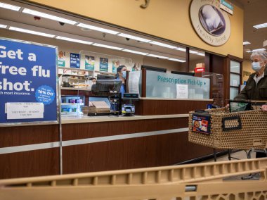 Kirkland, WA USA - Ekim 2021: Safeway 'deki bir marketten reçeteli ilaç alan yaşlı bir kadının görüntüsü