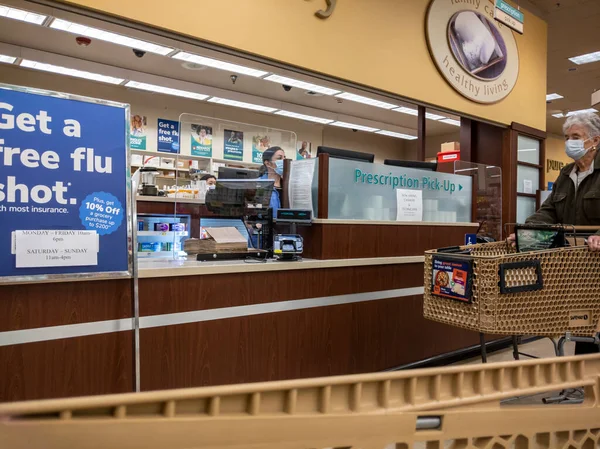Kirkland, WA USA - Ekim 2021: Safeway 'deki bir marketten reçeteli ilaç alan yaşlı bir kadının görüntüsü