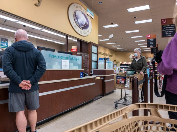Kirkland, WA USA - Ekim 2021: Safeway 'deki bir marketten reçeteli ilaç alan yaşlı bir kadının görüntüsü
